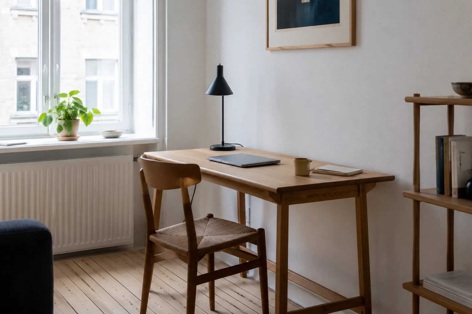 Vintage spisestol i træ med papirgarnssæde ved et skrivebord i et lyst hjemmekontor